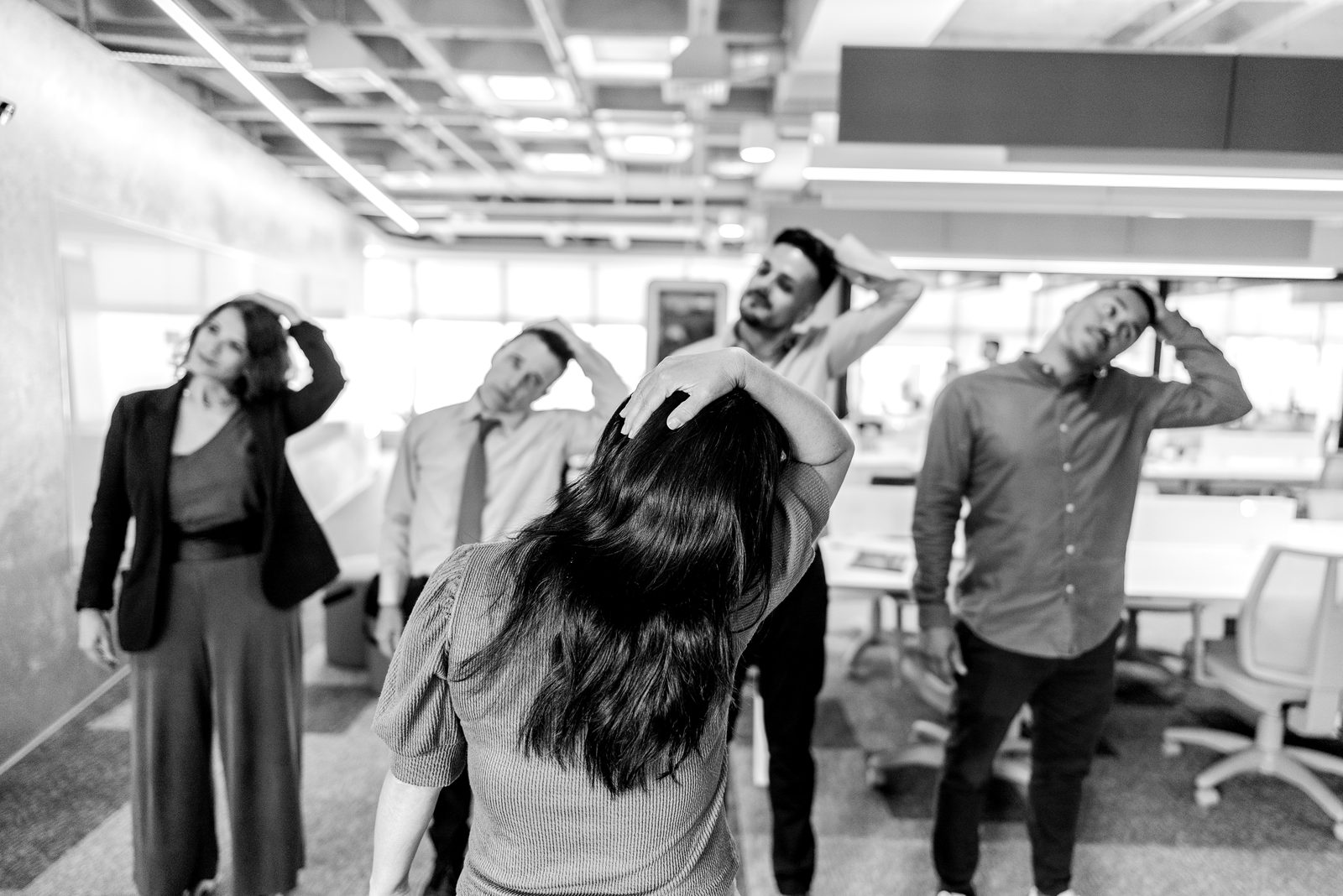 Equipo de trabajo estirándose juntos: bienestar en la oficina